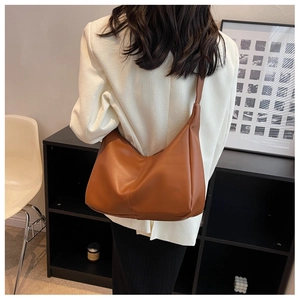 Close-up of brown faux leather shoulder tote bag showing texture and large capacity size