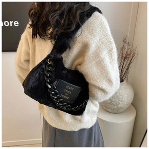 Detail of black fluffy faux fur tote bag featuring a chunky chain and model style styling