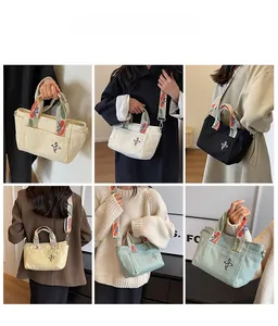 Canvas tote bag with floral embroidery and wide patterned strap shown in various colors
