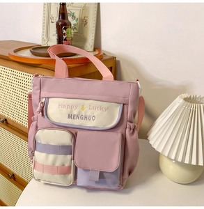 Detail of pink and purple nylon tote bag featuring multi-pockets and cute embroidery