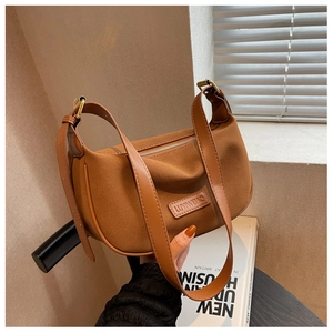 Detailed macro view of the brown suede hobo bag featuring leather trim and brand logo