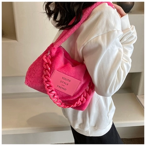 Macro detail of plush neon pink faux fur shoulder bag with thick resin chain strap