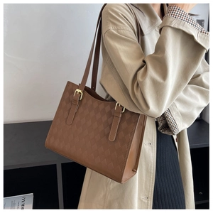 Macro detail of brown quilted tote bag showing high-quality texture and gold hardware