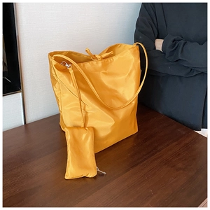 Dettaglio borsa tote in nylon giallo con coulisse e astuccio con cerniera abbinato