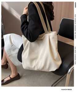 Minimalist off-white canvas tote bag with khaki straps shown on model for daily commute