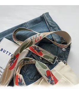 Detail of colorful jacquard woven strap with silver metal buckle on a beige canvas tote bag