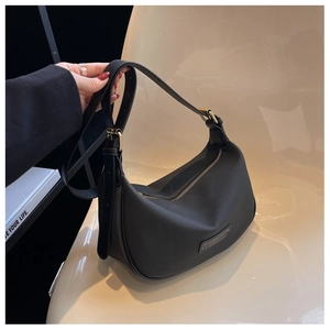 Detail of black matte nylon crescent hobo bag with adjustable strap and logo