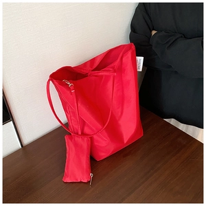 Dettaglio di una borsa tote rossa in tessuto Oxford con pochette e etichetta tessuta