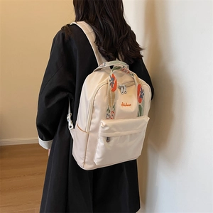 Sac à dos en nylon blanc crème avec bretelles jacquard fleuries et broderie rouge