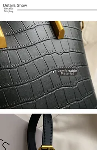 Macro shot of black crocodile embossed leather texture with gold metal hardware detailing