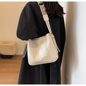 Detail of off-white leather bucket bag with wide geometric patterned jacquard strap