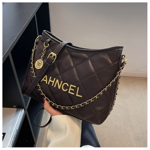 Detail of dark brown quilted leather bag with gold chain strap and metallic logo