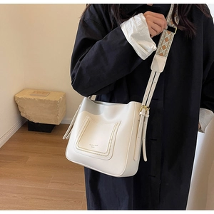 Detail of cream white PU leather tote bag with wide patterned woven shoulder strap