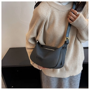 Detailed view of black crescent moon bag with silver zipper and wide adjustable strap