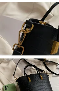 Detailed view of crocodile texture on black bucket bag with golden metal hardware