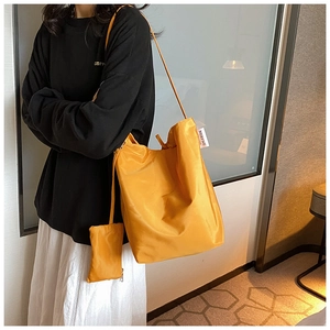 Dettaglio della borsa tote gialla in tessuto Oxford con mini astuccio sulla spalla
