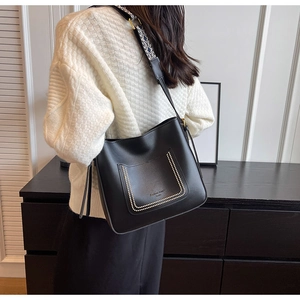 Detailed view of black PU leather bucket bag with jacquard wide strap and embossed logo