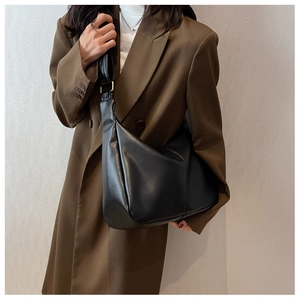 Chic black matte leather slouchy dumpling bag styled on a brown blazer outfit