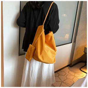 Dettaglio della borsa tote in nylon giallo con portamonete coordinato e trama liscia