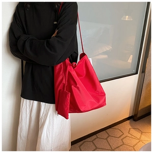 Dettaglio della borsa tote in tessuto Oxford rosso con piccolo astuccio coordinato a spalla
