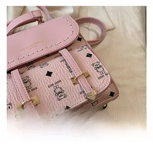 Vue détaillée du cuir rose grainé avec logo doré et motifs d'oursons mignons