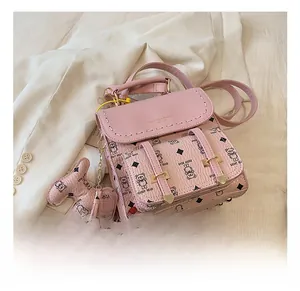 Vue détaillée du sac à dos en cuir rose avec motifs ours en peluche et boucle dorée