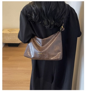 Detail of dark brown retro leather tote with golden FASHION & BAGS lettering
