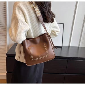 Detail of retro brown hobo bag featuring ethnic embroidered wide shoulder strap