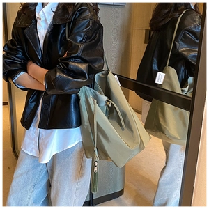 Dettaglio della borsa tote verde oliva che mostra il design ampio e l'etichetta