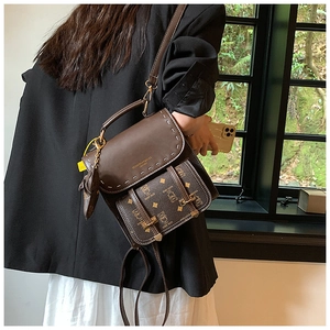 Détail du sac à dos vintage marron avec surpiqûres blanches et motif d'ours