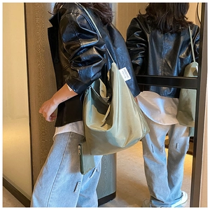 Dettaglio della borsa tote verde in nylon con mini pochette e tessuto riflettente