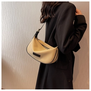 Detailed shot of the beige Hobo shoulder bag featuring black trim and leather logo patch