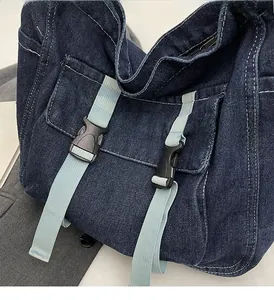 Macro detail of dark denim fabric with light blue contrast straps and plastic buckle