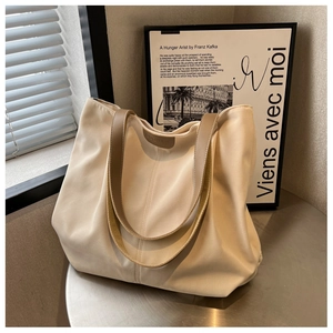 Close-up of the internal brown leather logo tag inside a beige canvas tote bag