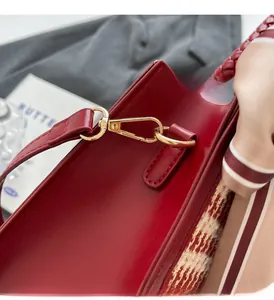 Close-up of glossy red handbag with premium gold hardware and red checkered details