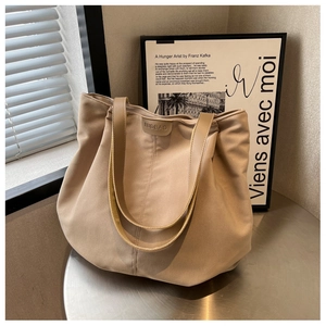 Detailed view of the brand logo and durable canvas texture on a beige tote bag