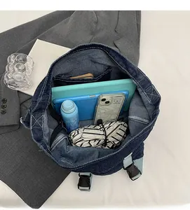 Detail view of large capacity dark blue denim backpack with zipper pocket and spacious interior