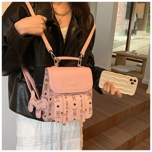 Détail du sac à dos rose en cuir PU avec chaîne dorée et poignée supérieure