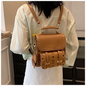 Détail du sac à dos vintage en cuir marron avec motif d'ours et ferrures dorées