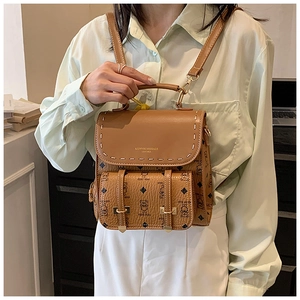 Vue détaillée du motif d'ours vintage marron et des coutures en cuir sur le sac à dos