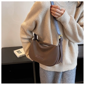 Close-up of brown matte faux leather hobo bag with adjustable strap and gold buckle