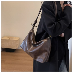 Detail of vintage brown tote bag with knotted shoulder strap and zipper closure