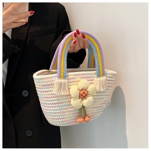 Détail d'un sac seau tissé main avec anse arc-en-ciel et fleur en relief 3D