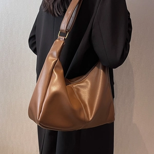 Brown leather crescent crossbody bag with minimalist shoulder strap for casual wear