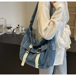Détail du sac fourre-tout en denim avec boucles et poches latérales à effet vieilli