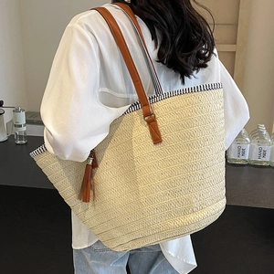 Large capacity straw woven tote bag with brown leather straps and summer tassel details