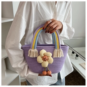 Détail du sac seau tissé violet avec anses arc-en-ciel et breloques de cerises florales