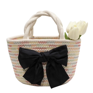 Borsa a secchiello intrecciata con cuciture a onde colorate e grande fiocco nero