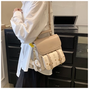 Détail du sac à dos en cuir beige avec motifs d'ours et coutures blanches contrastées