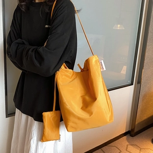Grande borsa tote arancione in tessuto Oxford con portamonete abbinato indossata